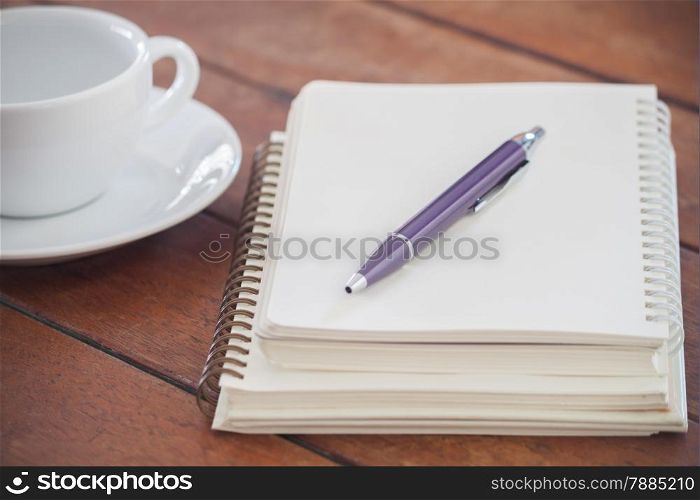Blank notebook with pen on wooden table, stock photo