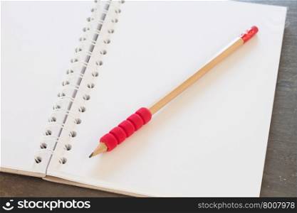 Blank notebook with pencil on grey background, business concept
