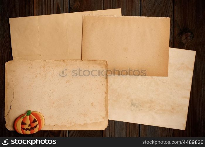 Blank old paper sheet and gingerbread cookie over dark wooden background. Halloween invitation.