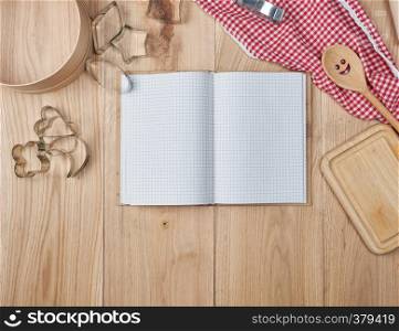 blank open notebook in line and wooden kitchen accessories, recipe concept, top view