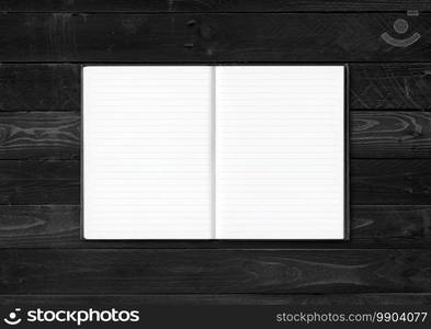 Blank open notebook mockup isolated on black wood background. Blank open notebook isolated on black wood background