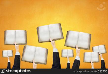 Blank opened book. Group of business people holding books in raised hands