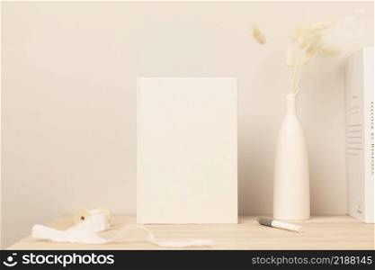 Blank paper card, greeting card mock up. decoration with dried Bunny Tail and pampas grass, Front view, Beautiful Bunny Tail grass in vase on wood table and beige cement wall background