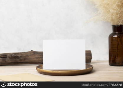 Blank paper card, greeting card mock up. decoration with dried Bunny Tail, Front view, Beautiful Bunny Tail grass in vase on wood table and beige cement wall background