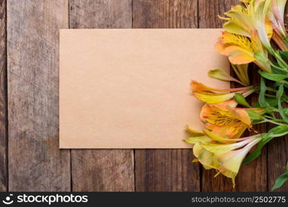 Blank paper card with lily flowers on old wooden table still life