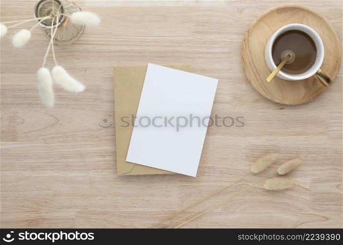 Blank paper cards, Blank greeting card invitation Mockup with Dried Bunny Tail grass in vase and coffee cup on wood table, wood desk background, Minimal wood table workplace composition, flat lay, mockup