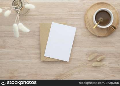 Blank paper cards, Blank greeting card invitation Mockup with Dried Bunny Tail grass in vase and coffee cup on wood table, wood desk background, Minimal wood table workplace composition, flat lay, mockup