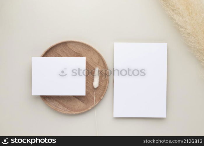 Blank paper cards, Mockup with pampas grass on a wooden plate, beige background, Minimal beige workplace composition, flat lay, mockup