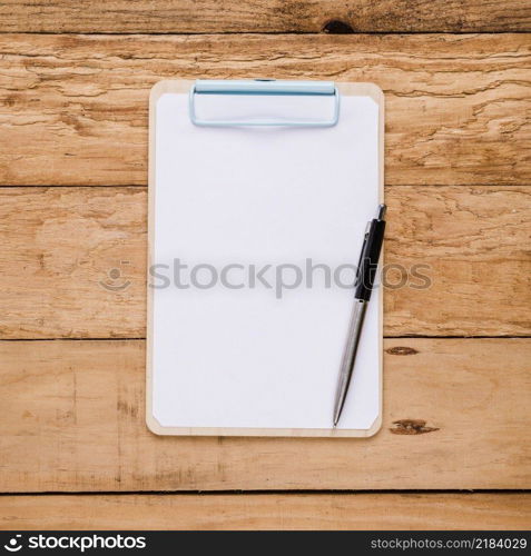 blank paper clipboard with ballpoint pen wooden desk