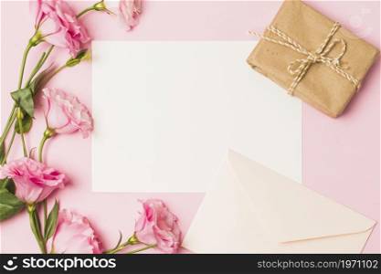 blank paper with envelop fresh pink flower brown wrapped gift box pink background. High resolution photo. blank paper with envelop fresh pink flower brown wrapped gift box pink background. High quality photo