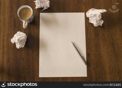 Blank paper with pen and coffee cup on wood table, space for text. Blank paper with pen and coffee cup on wood table space for text