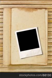 Blank photo frame with book on wood background