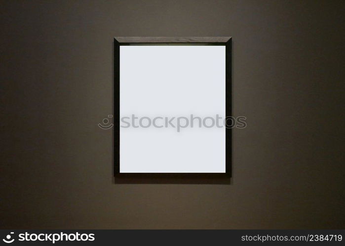 Blank picture frame hanging on black wall - framed poster mockup with dark wall background