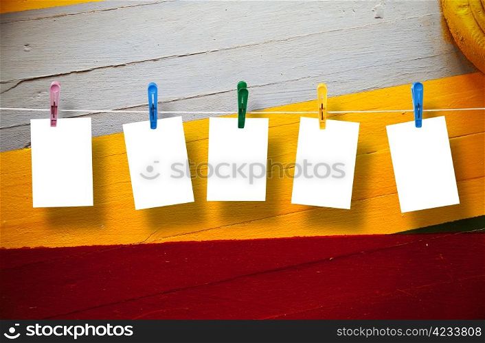 Blank picture frame hanging on clothesline on wood background