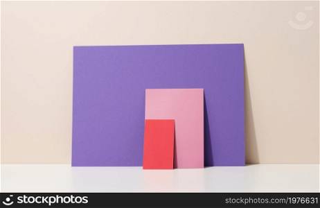 blank purple, pink cardboard sheet of paper with shadow on white table. Template for flyer, announcement