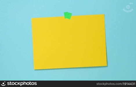 blank rectangular yellow sheet of paper glued on a blue background. Place for an inscription, announcement