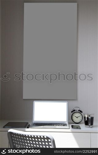blank screen laptop computer and smart phone and digital tablet and stylus pen and poster is on wooden desk as workplace concept