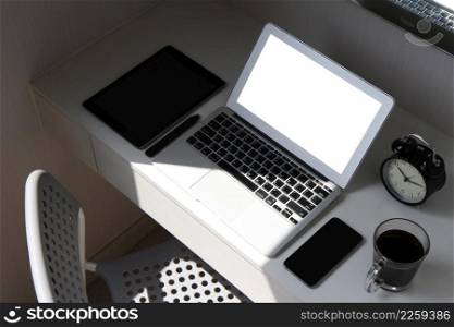 blank screen laptop computer and smart phone and digital tablet and stylus pen is on wooden desk as workplace concept