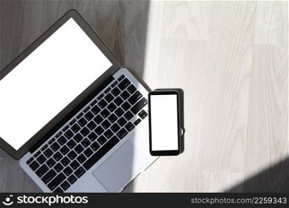 blank screen laptop computer with smart phone is on wooden desk as workplace concept