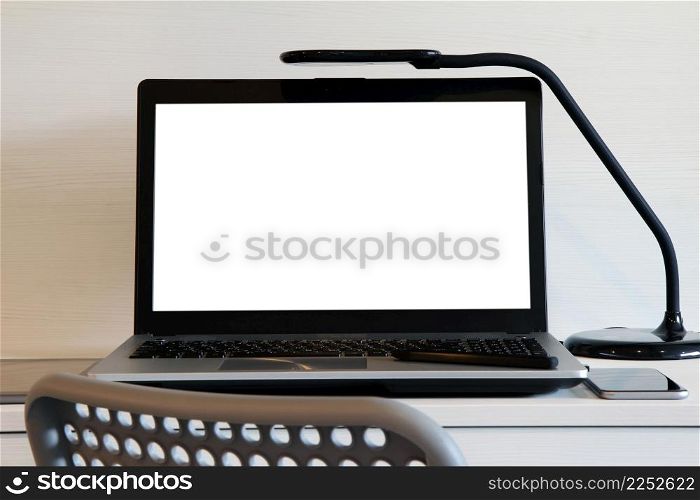 blank screen laptop computer with table lamp is on twooden desk as workplace concept