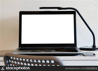 blank screen laptop computer with table lamp is on twooden desk as workplace concept