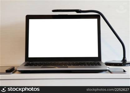 blank screen laptop computer with table lamp is on wooden desk as workplace concept