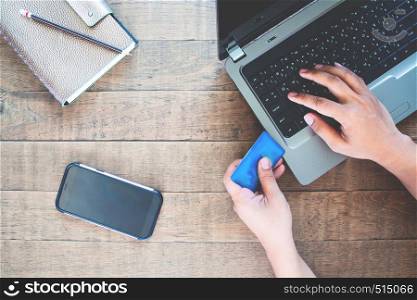Blank screen smartphone for application mock up with man using credit card and laptop computer