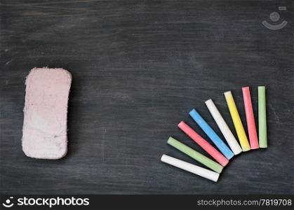 Blank smudged blackboard background with colorful chalk and eraser for text writing and design