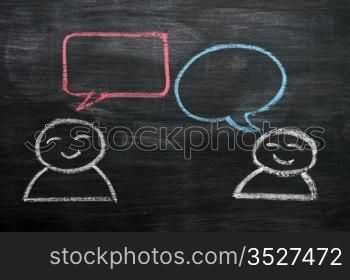 Blank speech bubbles with cartoon figures drawn on a blackboard background