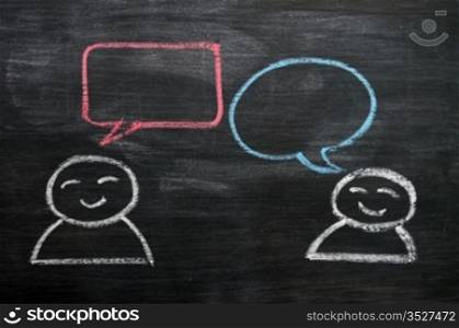 Blank speech bubbles with cartoon figures drawn on a blackboard background