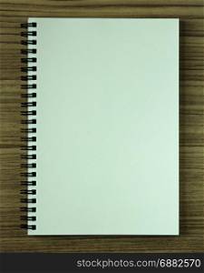 blank spiral notebook on wood background
