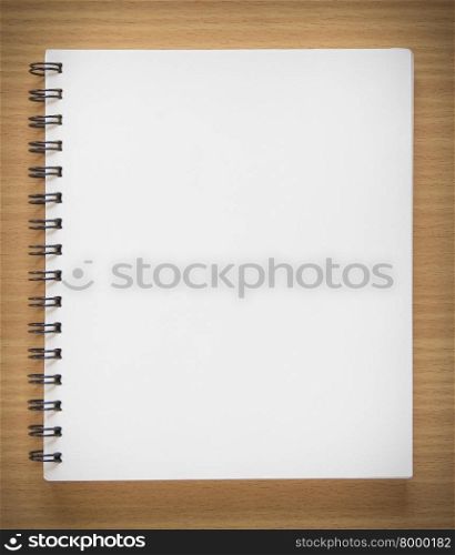 blank spiral notebook on wood background