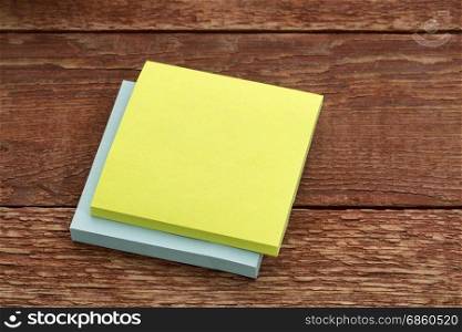blank sticky note against rustic barn wood table