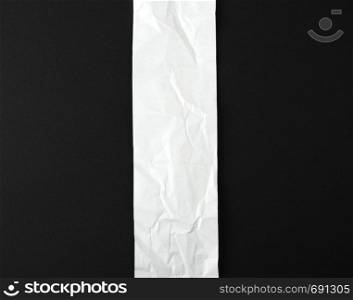 blank strip of paper on a black background, close up