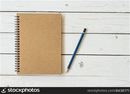 Blank vintage paper notebook with pencil on wood table