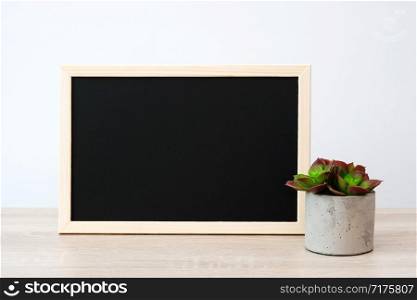 Blank vintage wood chalkboard, blackboard on table over white wall background, template for text