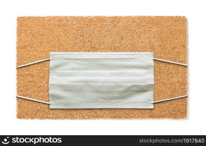 Blank Welcome Mat With Medical Face Mask Isolated on White Amidst The Coronavirus Pandemic.