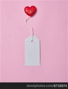 Blank white cardboard tag on white rope, pink background