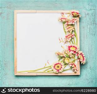 Blank white chalkboard and pretty flowers bunch on turquoise shabby chic background, top view