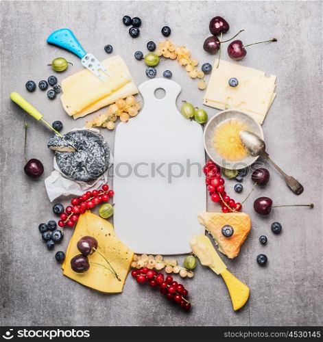 Blank white cutting board and various cheese with knife ,berries and honey, top view, frame