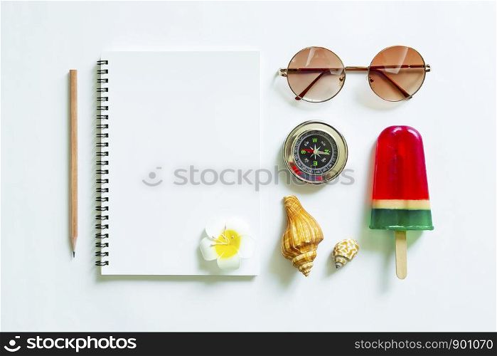 Blank white notebook with pencil and travel accessories on white background. Travel and summer concept.