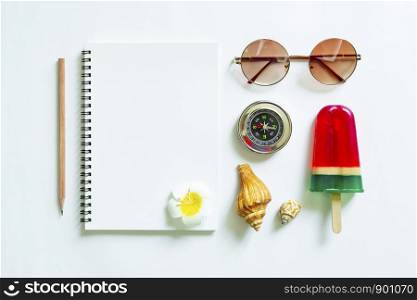 Blank white notebook with pencil and travel accessories on white background. Travel and summer concept.