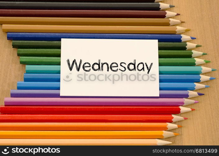 Blank white paper and colored pencils on wooden background