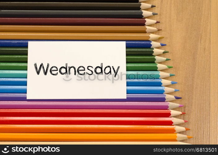 Blank white paper and colored pencils on wooden background