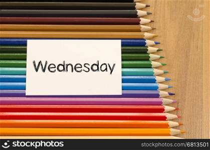 Blank white paper and colored pencils on wooden background