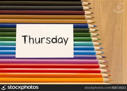 Blank white paper and colored pencils on wooden background