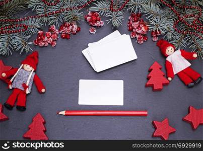 blank white paper business cards on a black background and a red pencil, top view