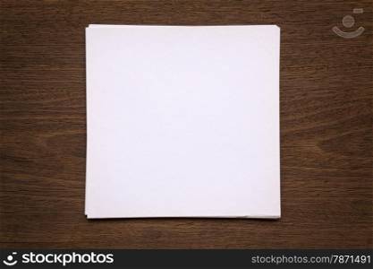 Blank white paper note putting on wood background with vignette
