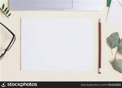 blank white paper pencil eyeglasses leaves laptop beige backdrop. High resolution photo. blank white paper pencil eyeglasses leaves laptop beige backdrop. High quality photo