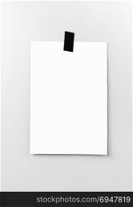 Blank white poster hanging on a tape on the wall. Template background for your design.. Blank white poster hanging on a tape on the wall. Template backg